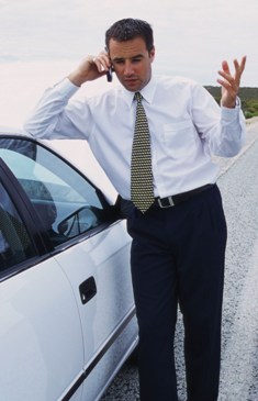 Мужчина рядом с автомобилем разговаривает по мобильному телефону
